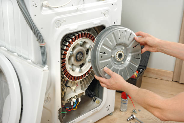 Фото Мастер по ремонту крупной бытовой техники обслуживает стиральную машину